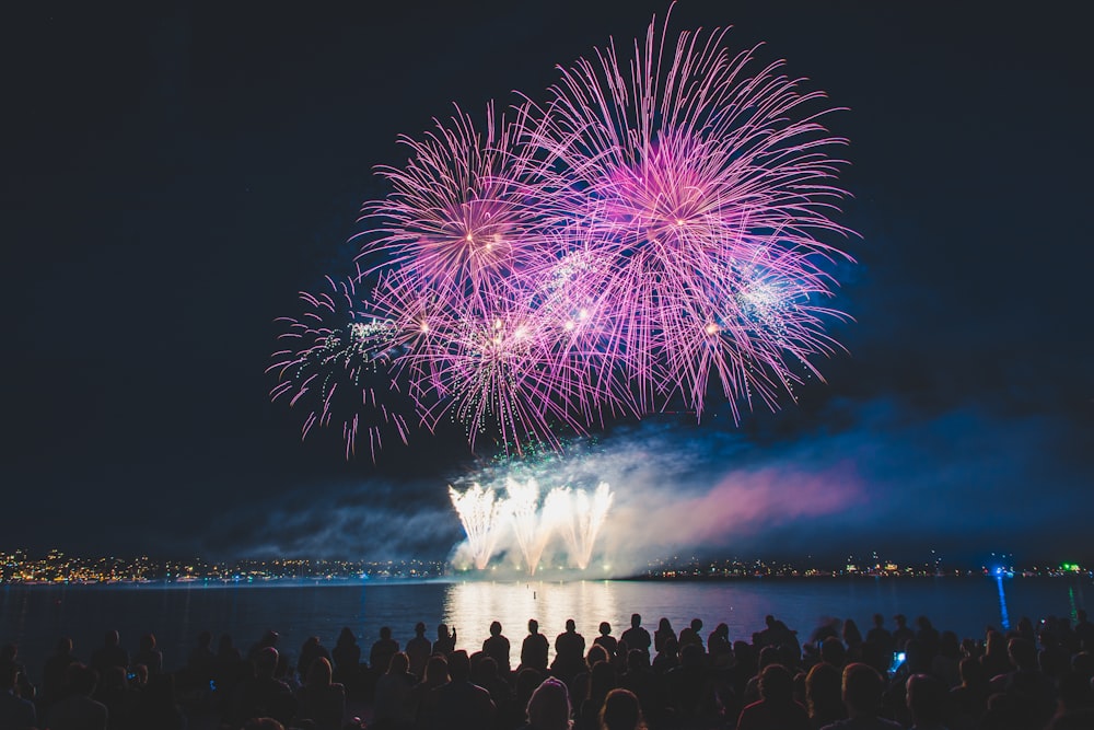 crowded people watching fireworks at night