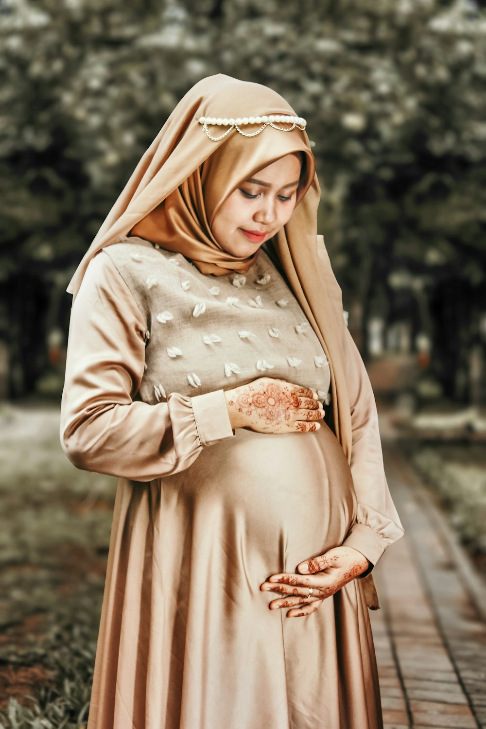 pregnant woman standing wearing brown dress