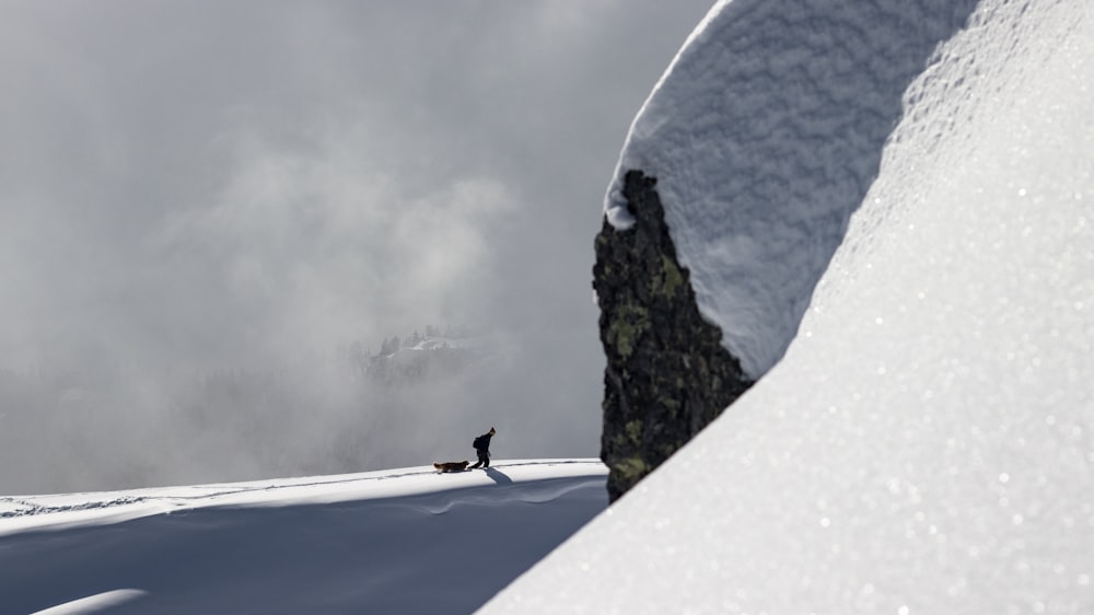 a person standing on top of a snow covered slope