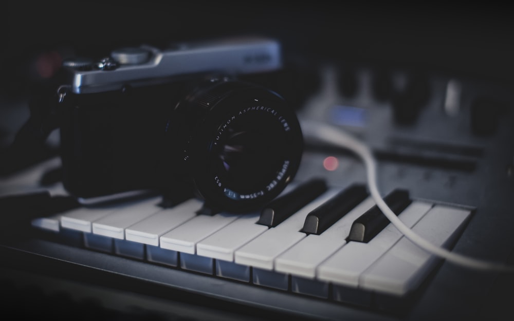 black and gray SLR camera on keyboard