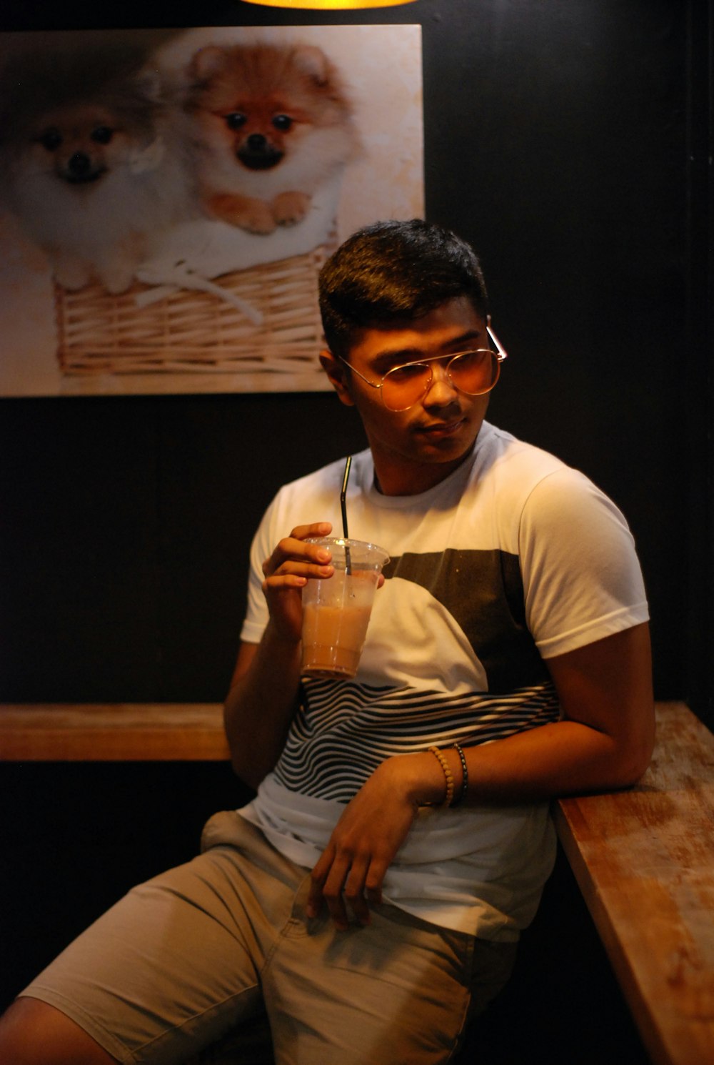 man wearing white shirt holding container with liquid