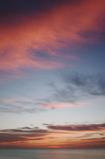 A vibrant sunset blending deep blues and golds, with clouds shaped like musical notes