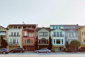 gray sedan parked near multicolored building during daytime