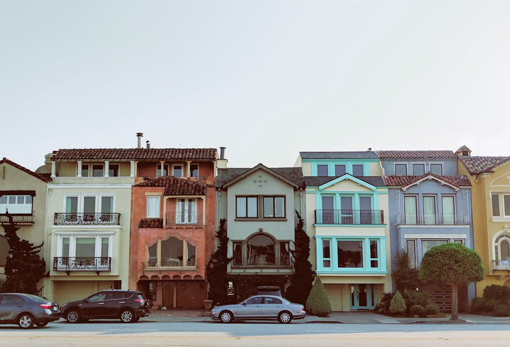 gray sedan parked near multicolored building during daytime