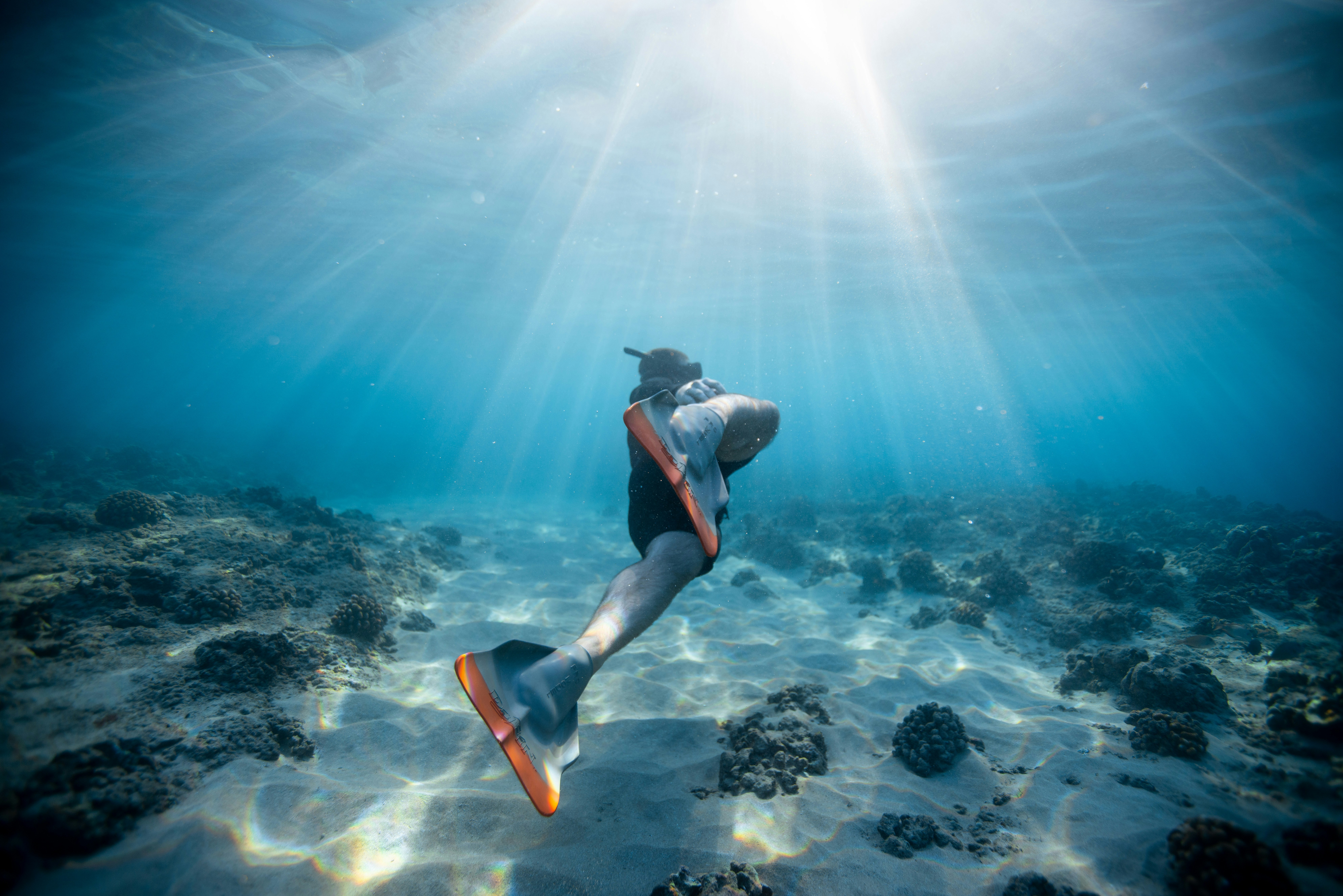 Scuba diver swimming in crystal clear blue ocean water - Jeremy Bishop on Unsplash