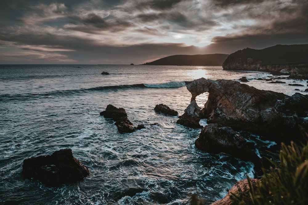 body of water near the rock formation during daytime