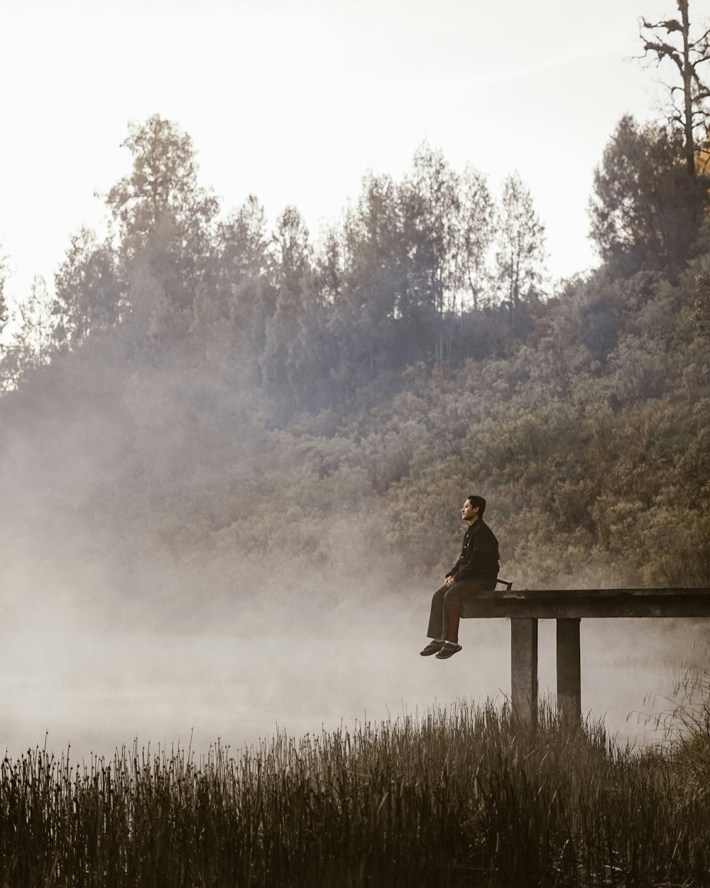 man sitting on boardwalk