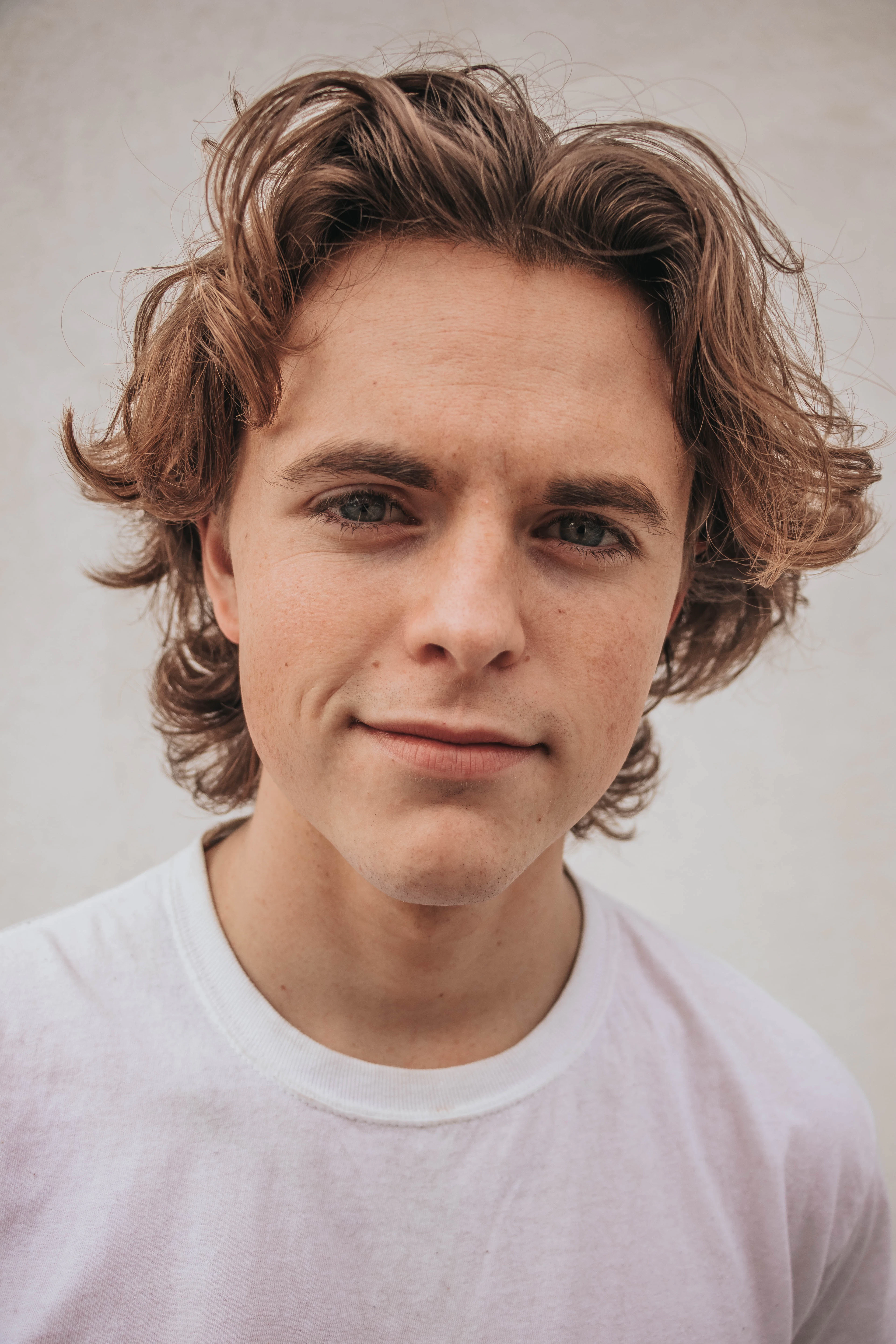 Portrait of a smiling faculty member with wavy hair