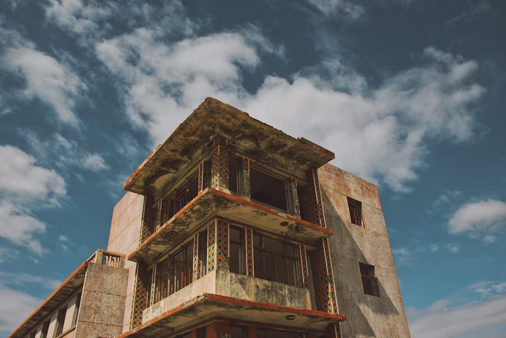 brown and grey concrete building under white clouds