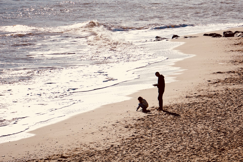 two person standing in beach during daytime