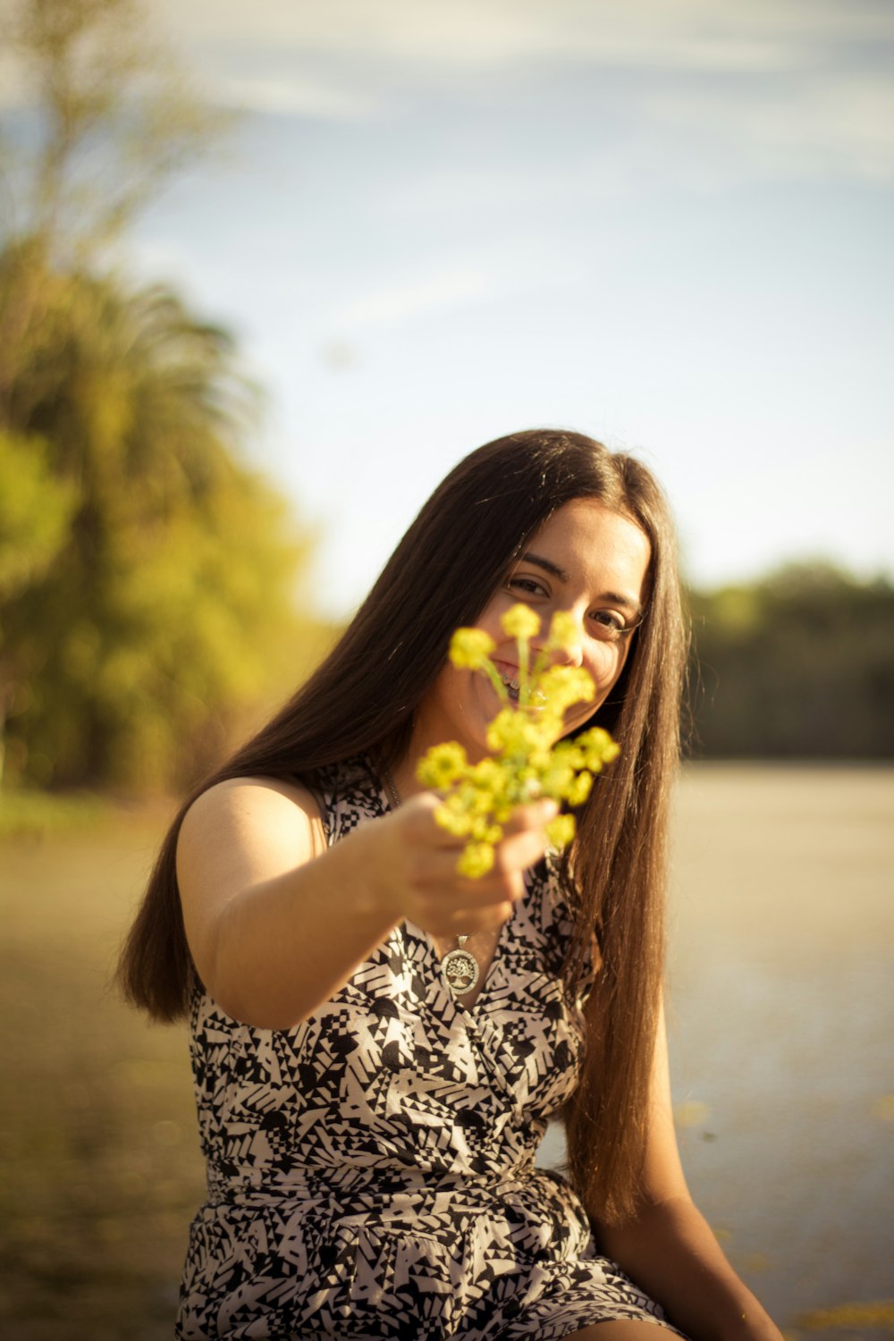 woman holding yellow flower during daytime