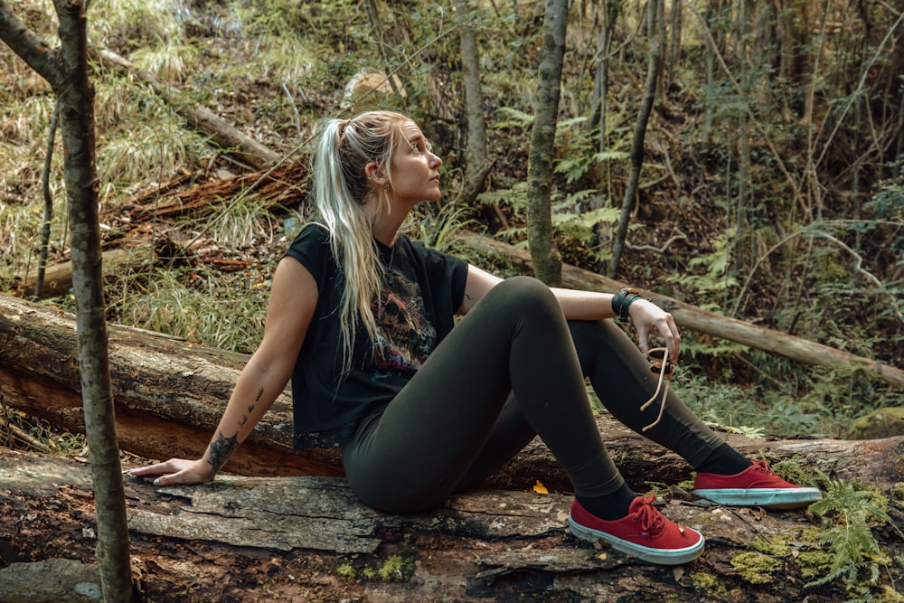 woman seating on a bark in the forest