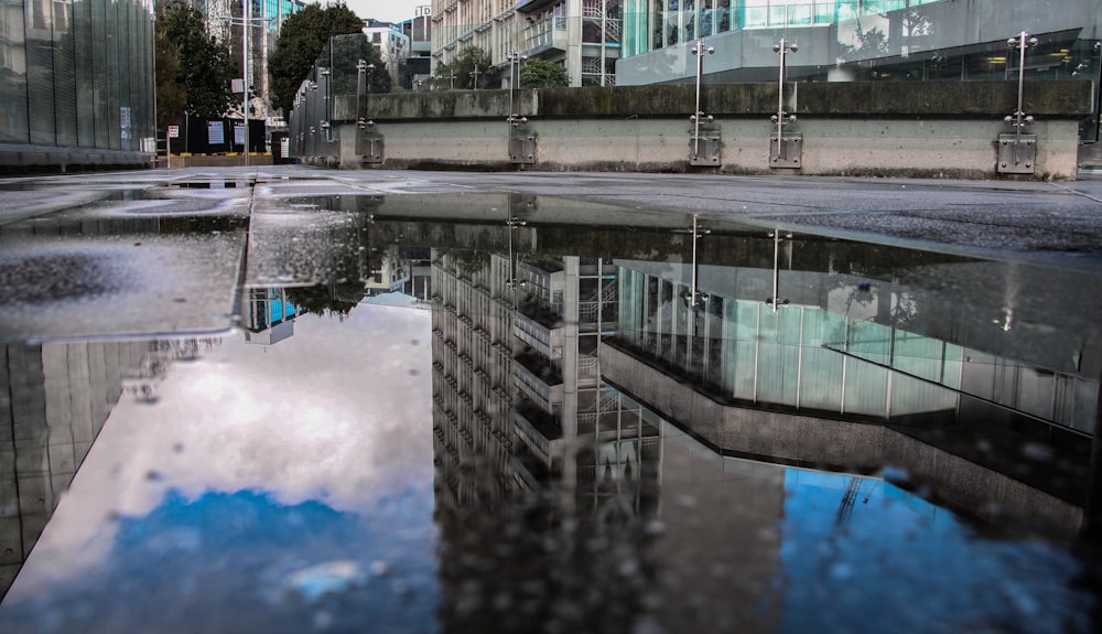 gray building reflecting on water during daytime