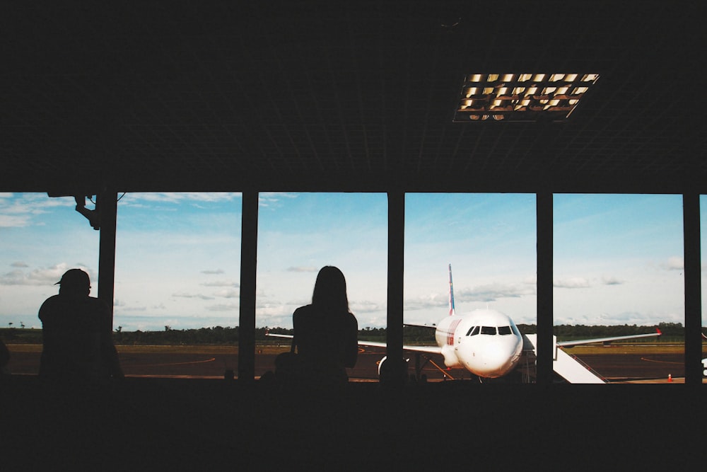 a group of people looking out a window at an airplane