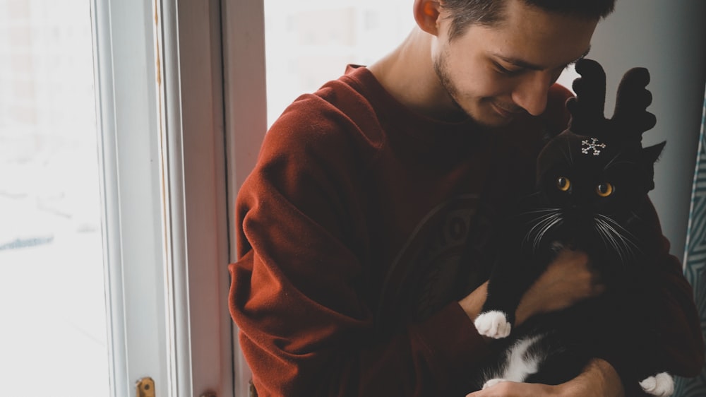 man holding cat near door