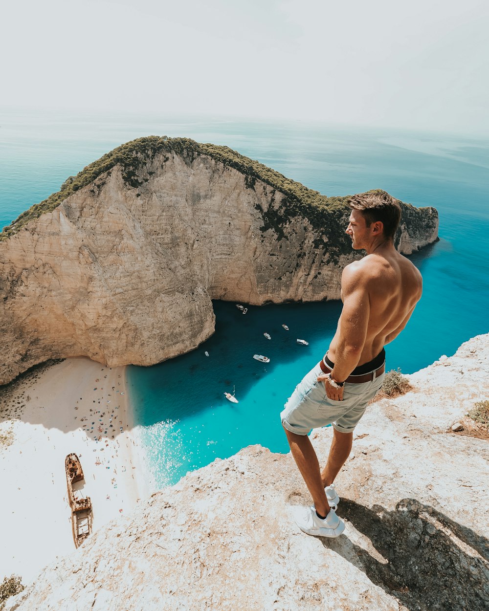 man standing on rock near body of water during daytime