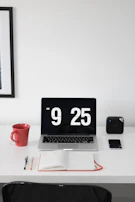 A calm workspace featuring a neat desk, a coffee cup, and a digital clock showing precise time.