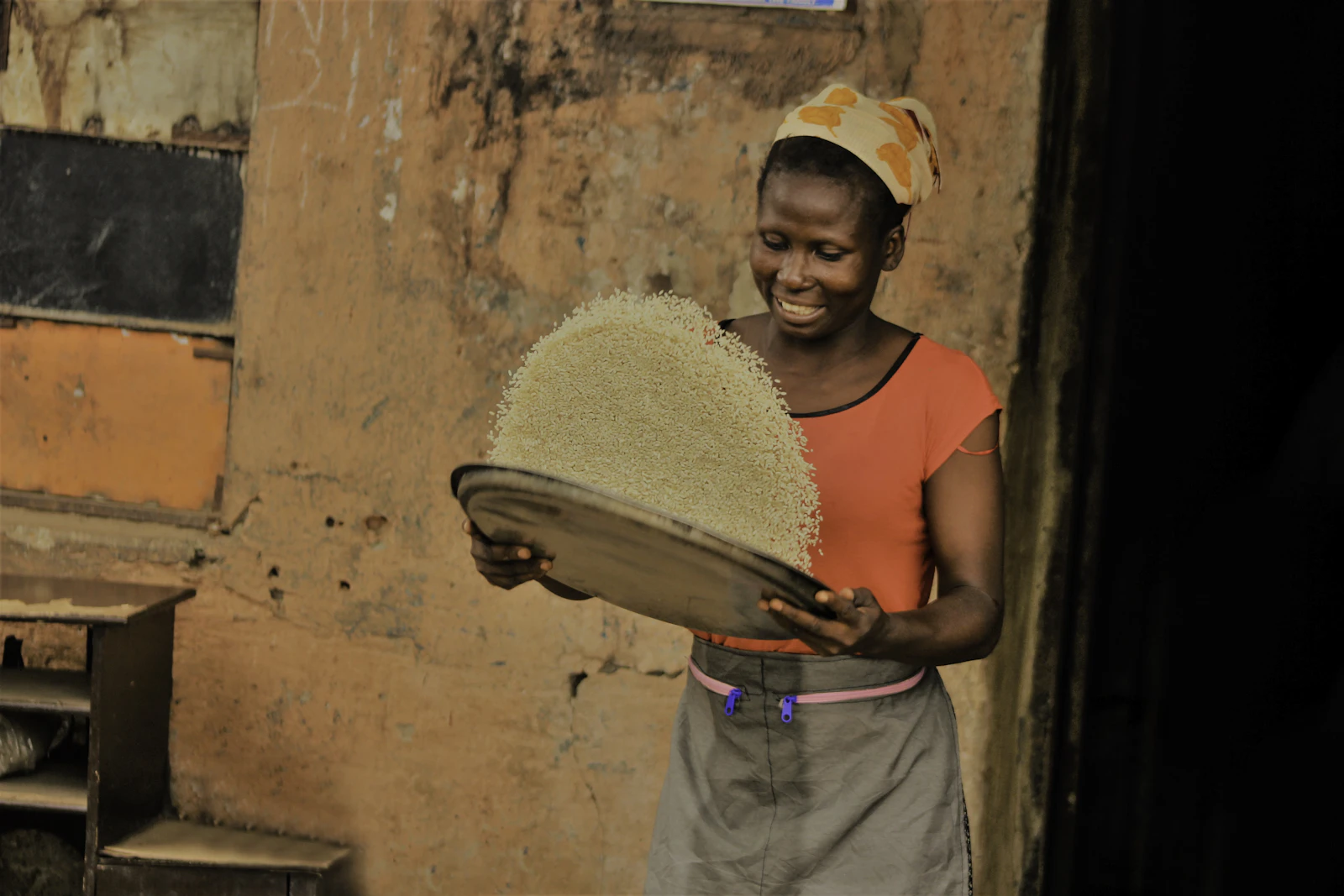 Nigerian woman holding a basket of Ofada rice in Lagos