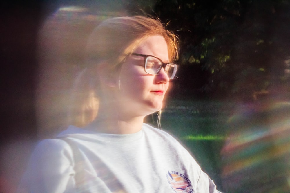 woman wearing white crew-neck top standing on green grass field