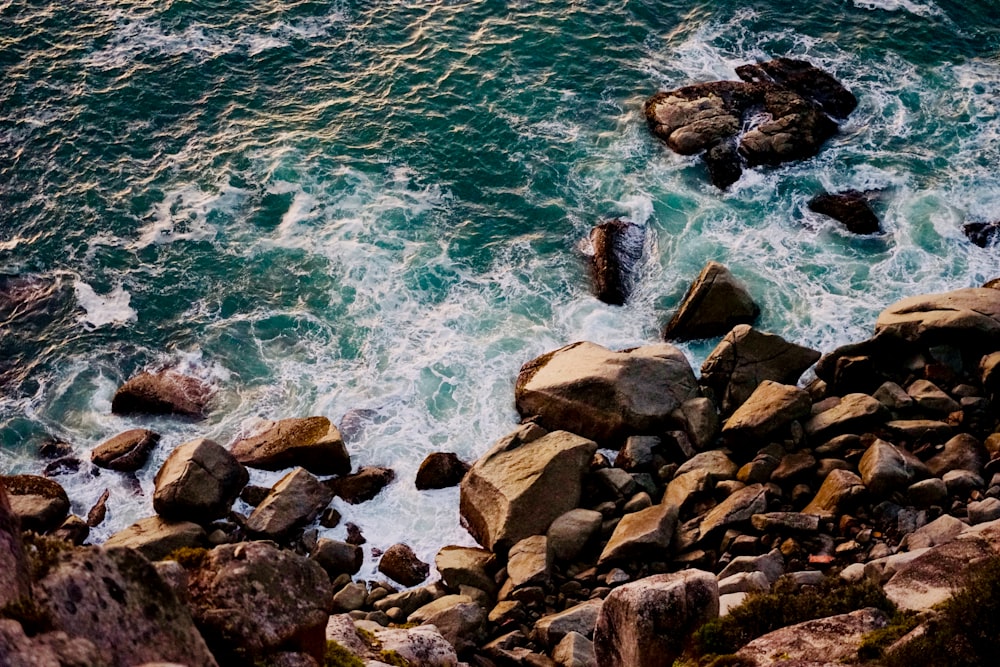 ocean wave splashing on rocks during daytime