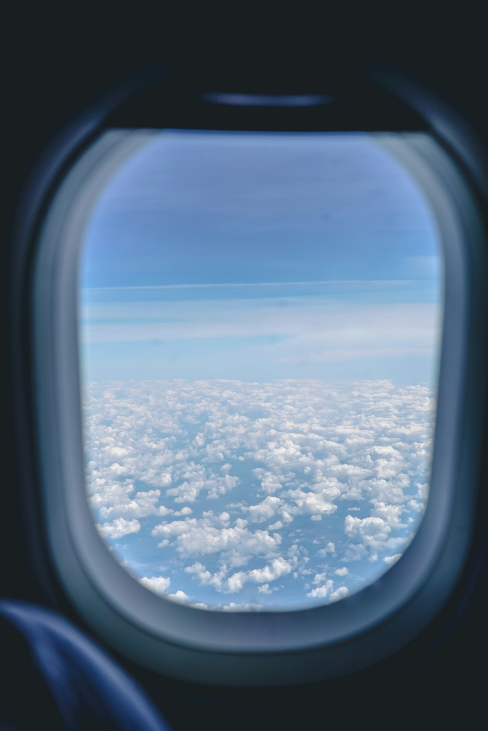 clouds on mid air taken from the inside of a plane at daytiem