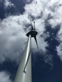 Engineers inspecting a large wind turbine on a breezy day