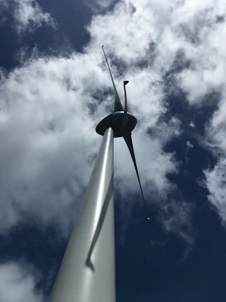 Engineers inspecting a large wind turbine on a breezy day