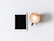 A close-up of a tablet on a desk with a coffee cup beside it.