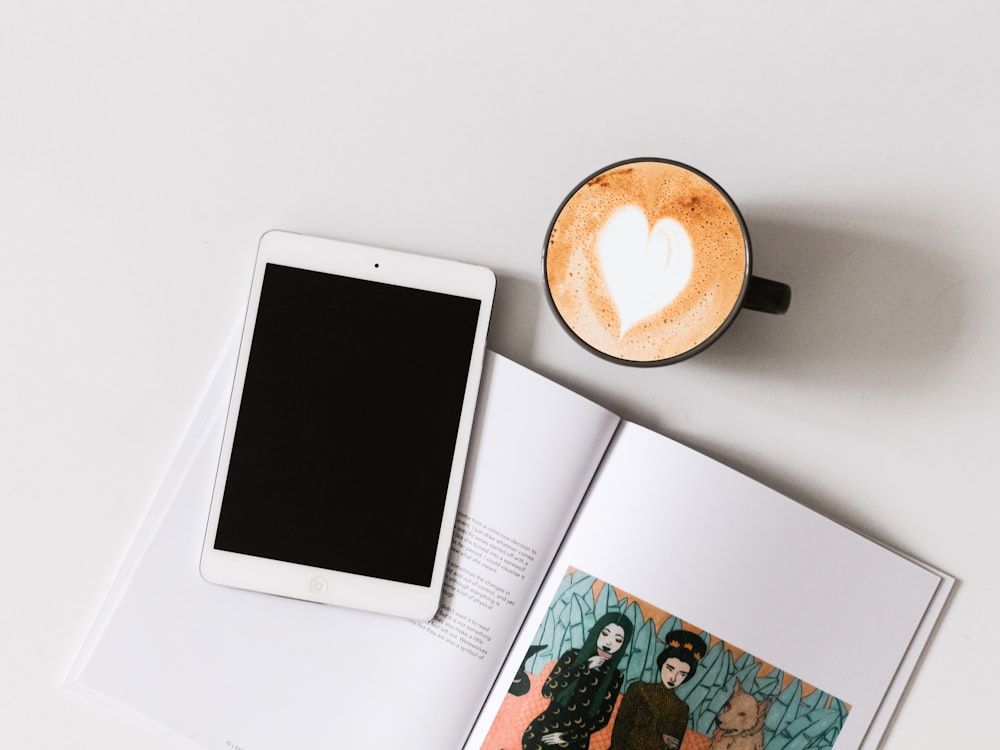 flatlay photography of iPad, book, and espresso coffee