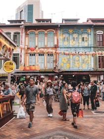 A scenic view of a bustling Southeast Asian street with colorful shops and smiling locals.