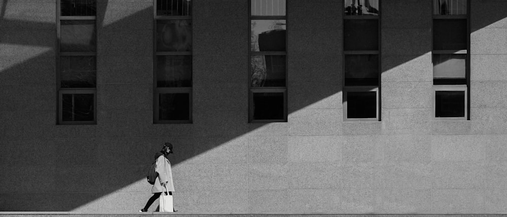 grayscale photo of man walking on street