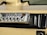 A vintage RadioShack TRC-447 CB radio installed in a vehicle dashboard. The device features various knobs and buttons for controls like volume, squelch, and gain. The dashboard is beige and black with a textured surface and mounting screws.