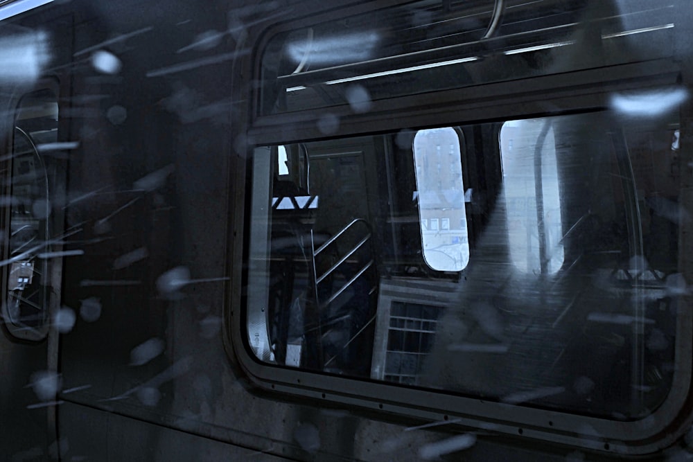 a view of a train through a window in the rain