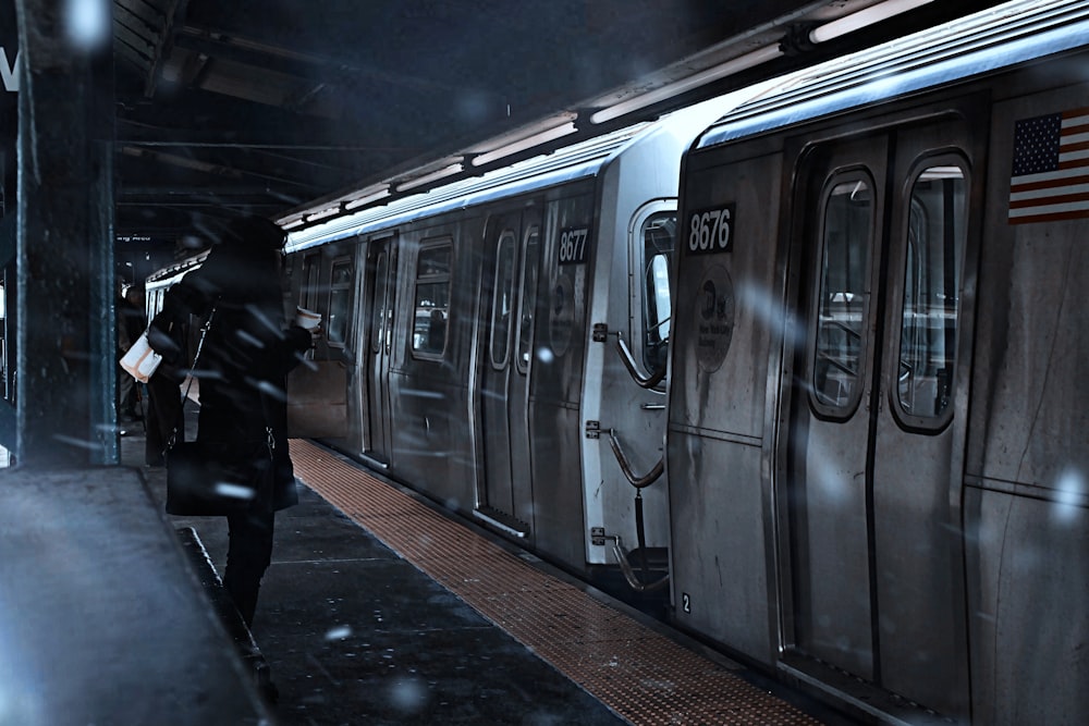 電車の近く、地下鉄に立つ黒いジャケットを着た人