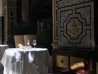 Elegant dining tables set with traditional Albanian dishes under soft candlelight inside the castle.