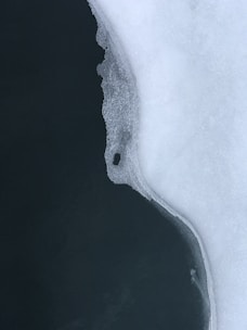 an aerial view of a body of water covered in snow