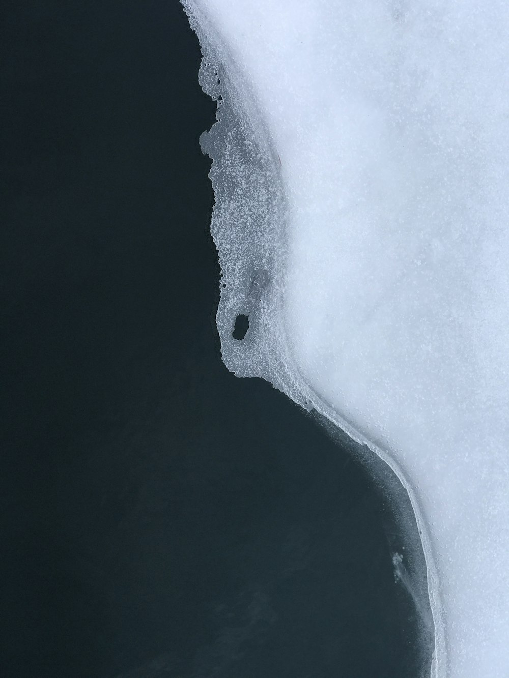 an aerial view of a body of water covered in snow