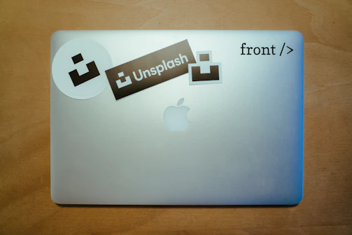 Hand applying a custom vinyl sticker onto a laptop surface.