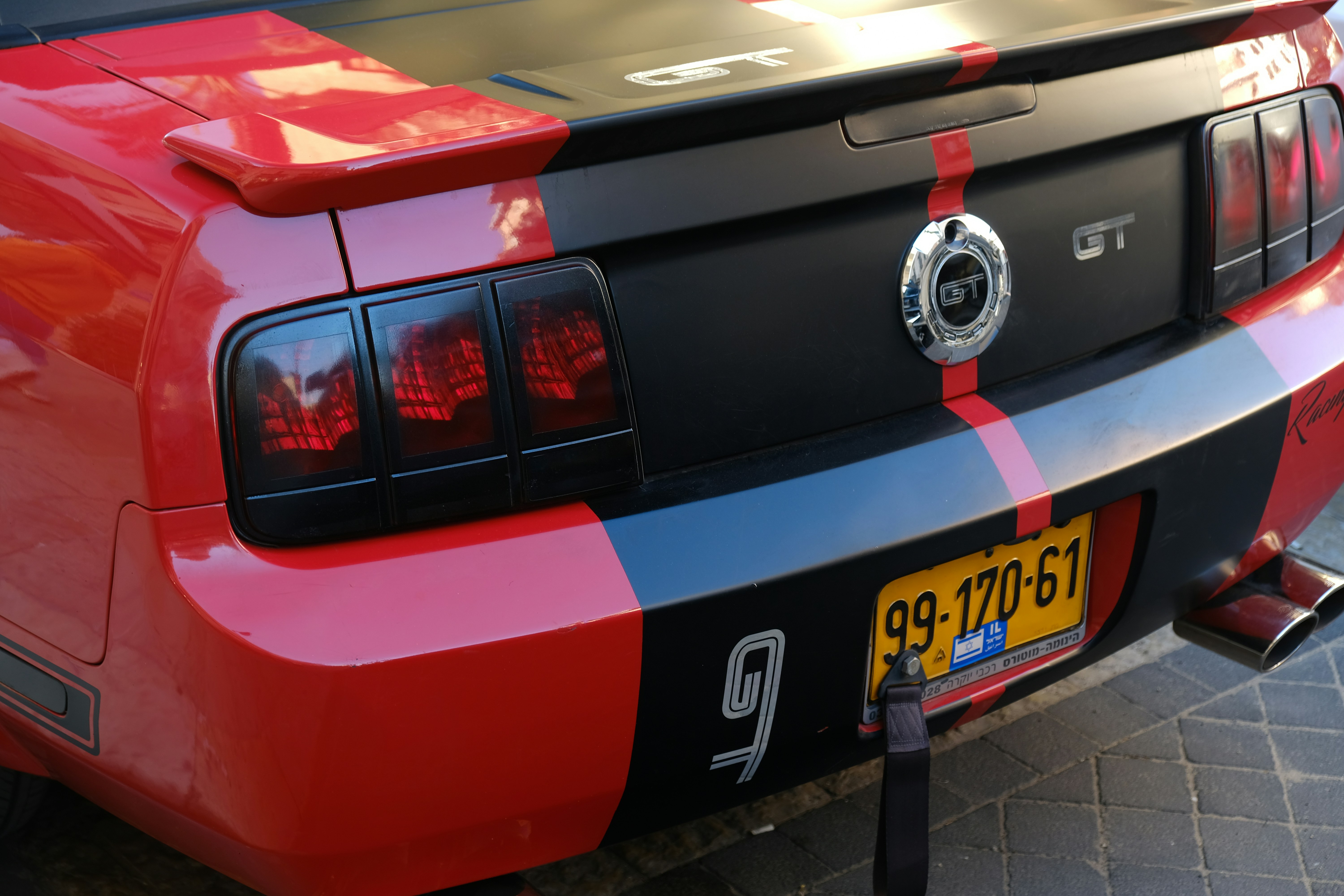 Matte black Ford Mustang GT with aftermarket exhaust at car show