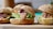 Three freshly made sandwiches with sesame seed whole-grain buns filled with lettuce, bacon, red onion slices, and cheese, placed on a wooden board.