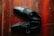 A pair of black leather shoes is placed on a polished wooden floor. The shoes are neatly positioned, and the texture of the wood creates a warm contrast with the smoothness of the leather.