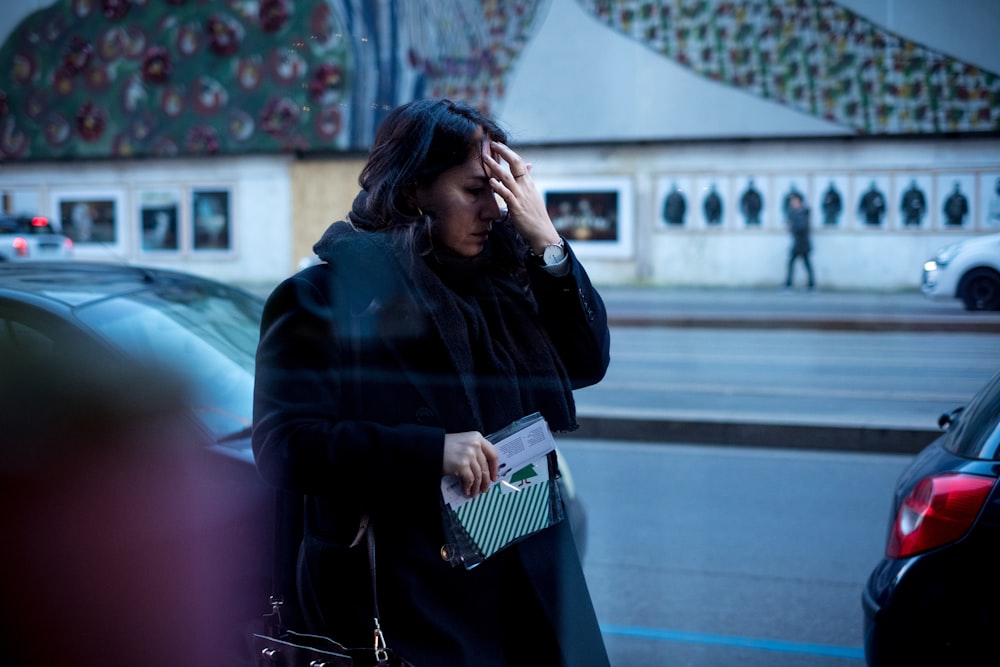 woman holding her forehead outdoor