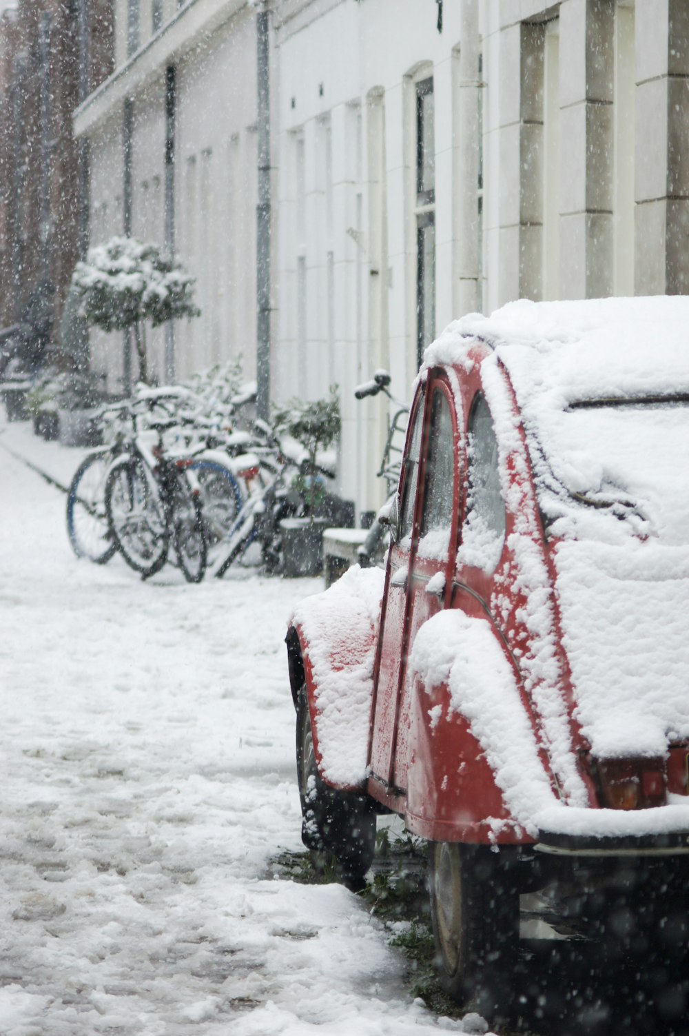 red Volkswagen beetle covered with snow