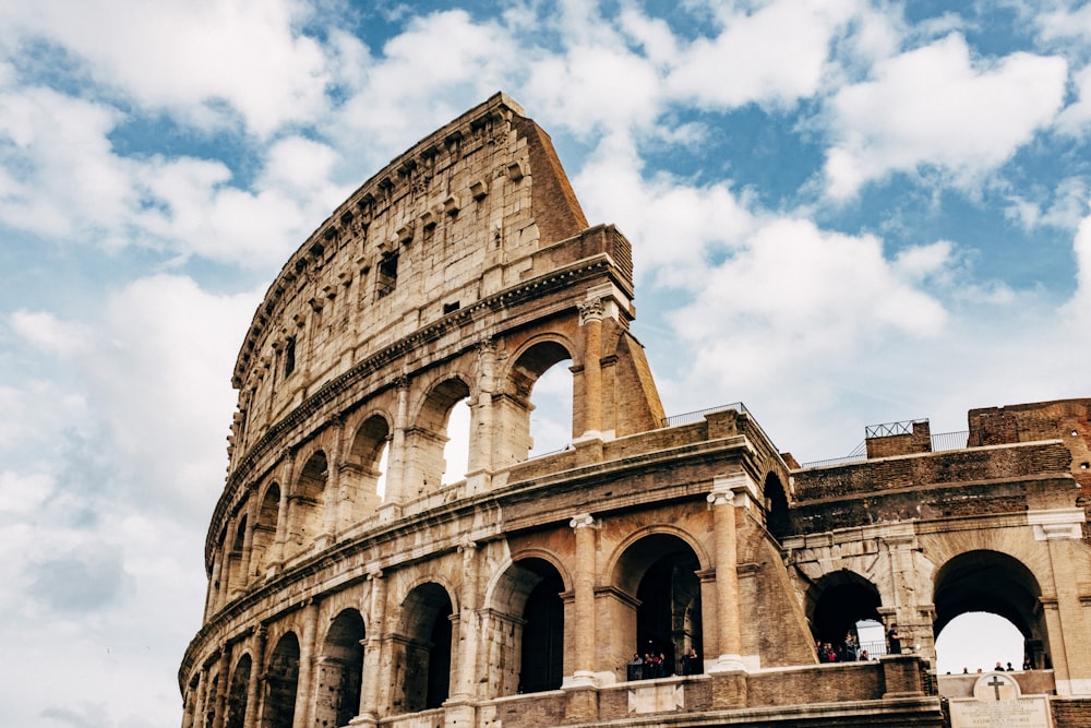 Colosseum under white clouds during daytime