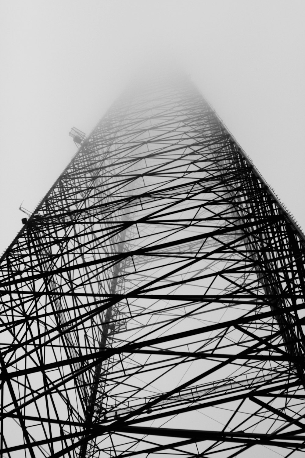 low angle photography of steel tower under cloudy sky