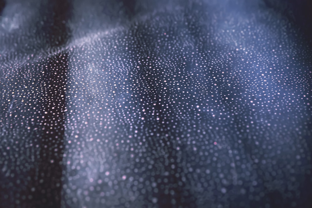 a close up of rain drops on a black surface