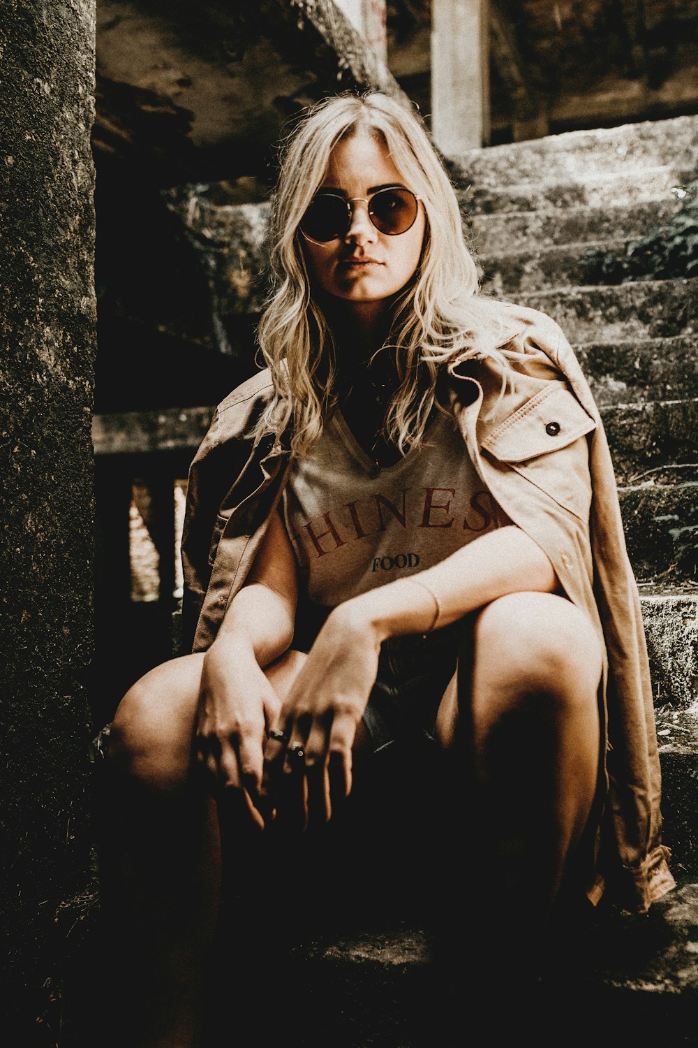 woman sitting in stair wearing brown jacket