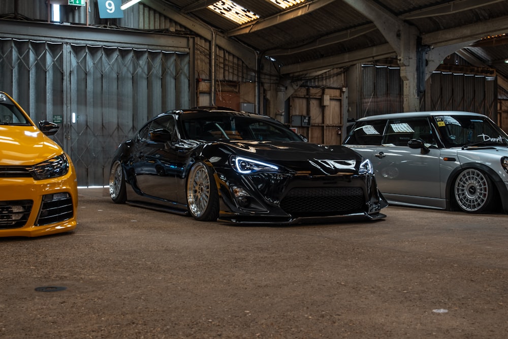 black coupe parked between two vehicles