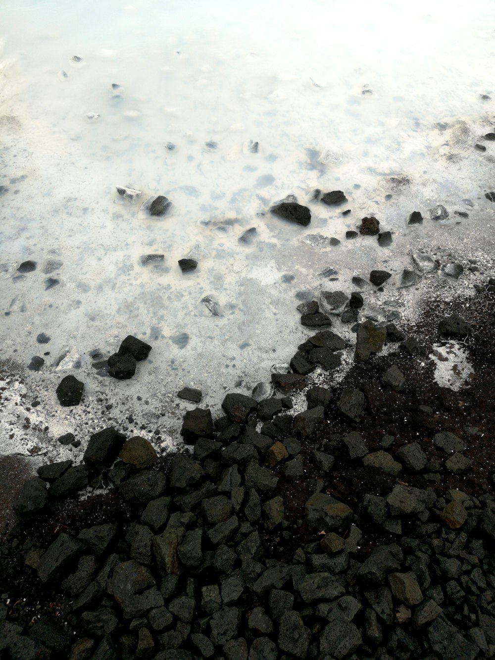 body of water beside rocks