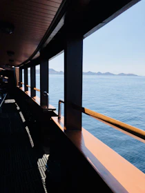 A minimalistic modern boat interior with wide windows overlooking the sea.